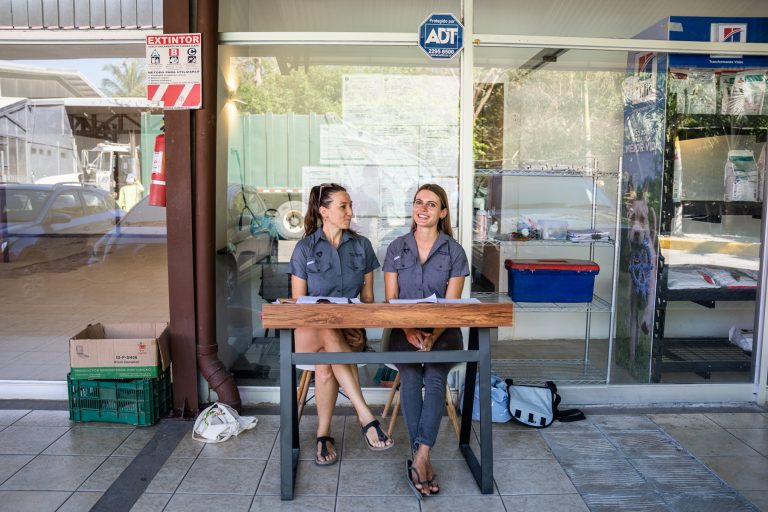 Two women sitting at a desk, in front of a veterinary clinic, ready to receive animal owners for a spay and neuter campaign, in Guanacaste Costa Rica.